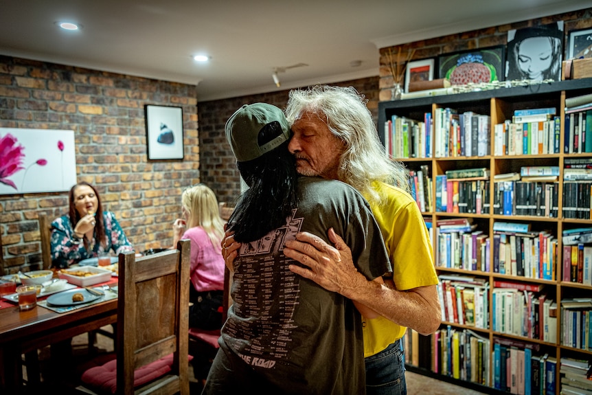 Chris Pearson hugs his surviving daughter.