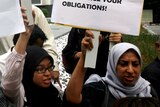 Human rights activists protest outside the signing ceremony in Kuala Lumpur.