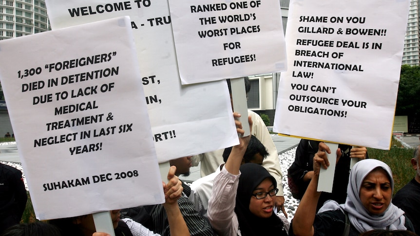 Human rights activists protest outside the signing ceremony in Kuala Lumpur.