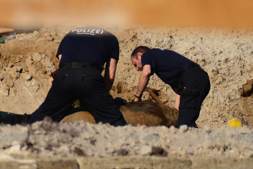 Experts prepare a WWII bomb for removal in Berlin, Friday, April 20, 2018.