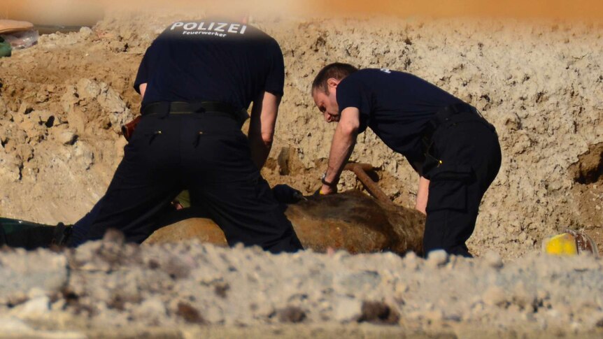 Experts prepare a WWII bomb for removal in Berlin, Friday, April 20, 2018.