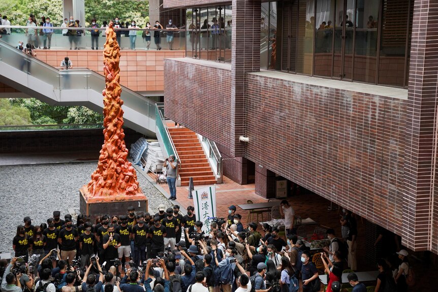 University students observe a minute of silence in front of the “Pillar of Shame” statue at the University of Hong Kong.