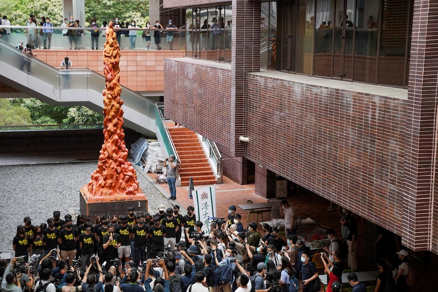 University students observe a minute of silence in front of the “Pillar of Shame” statue at the University of Hong Kong.