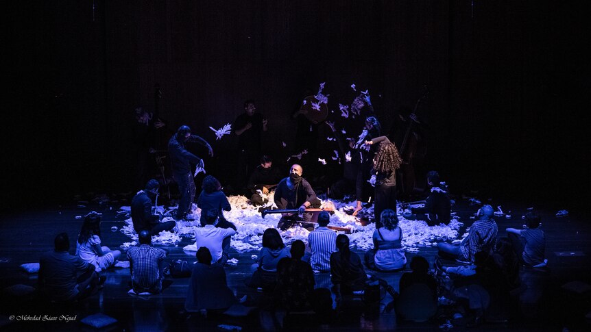 an opera stage covered in fluffed cotton with bodies moving within