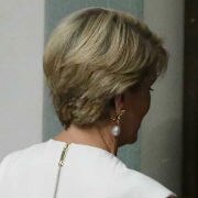 Dressed in white, Julie Bishop leaves through the doors of the House in Canberra.