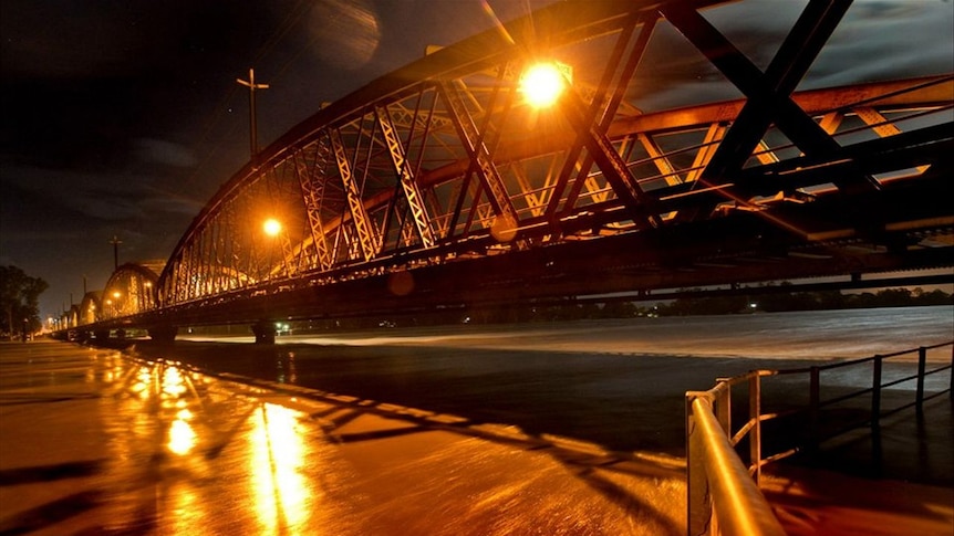 Flood waters in the Burnett River flow under the Burnett Bridge in Bundaberg