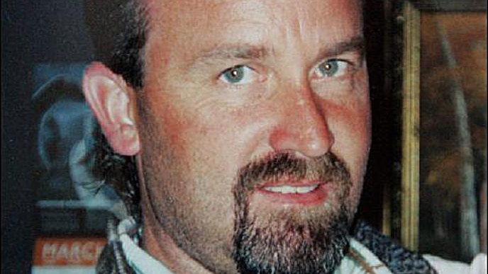 An historic photo of a 36-year-old man's face. He has green eyes and a goatee. 
