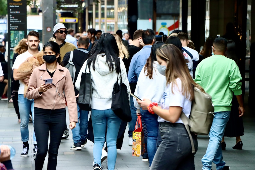 Crowd of shoppers in Sydney's Pitt St Mall, some wearing masks, post-lockdown during COVID pandemic.