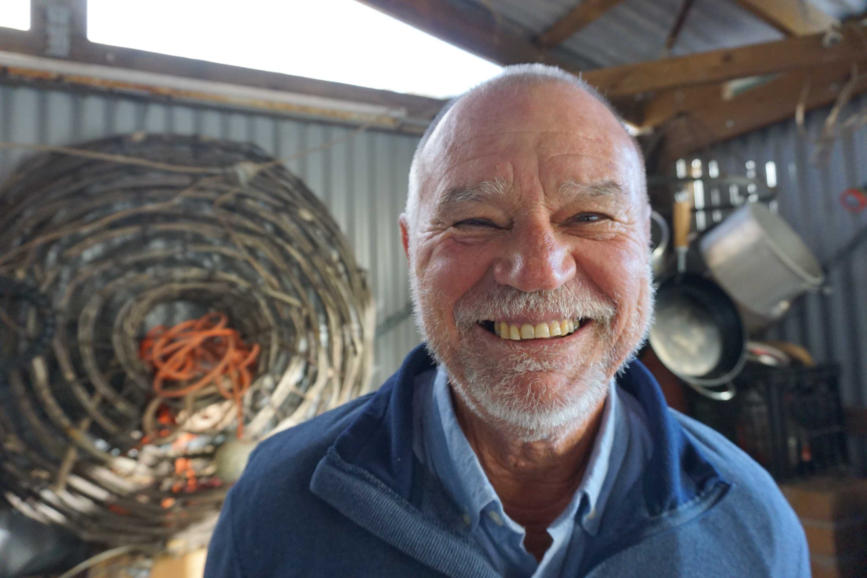 An older man smiling into the camera