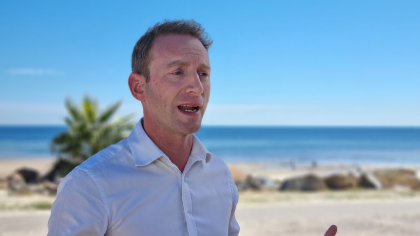 David Speirs giving a press conference in front of a beach in Adelaide.