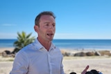 David Speirs giving a press conference in front of a beach in Adelaide.