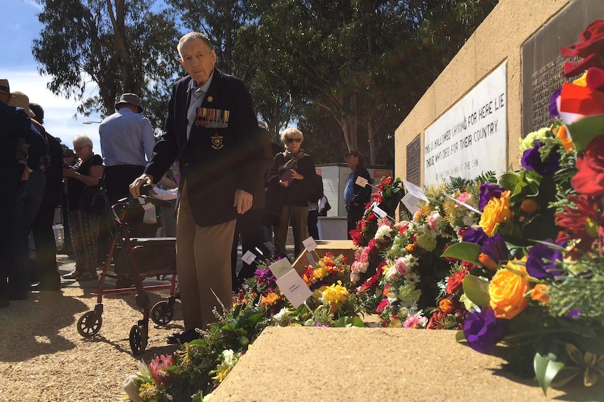 A "Rat" of Tobruk leaves flowers at the memorial in Canberra.