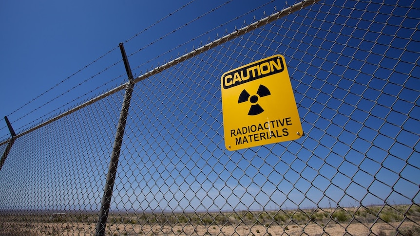 A Nuclear warning sign on a fence.