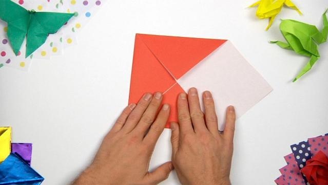 Hands fold paper into origami shape
