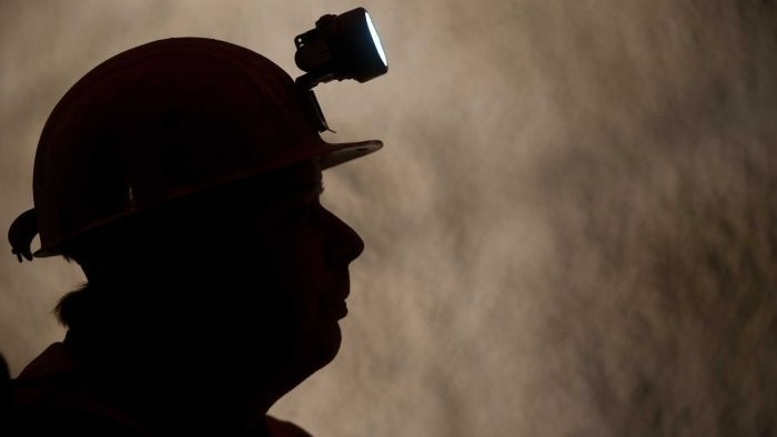 A silhouette of a man in a mining helmet.