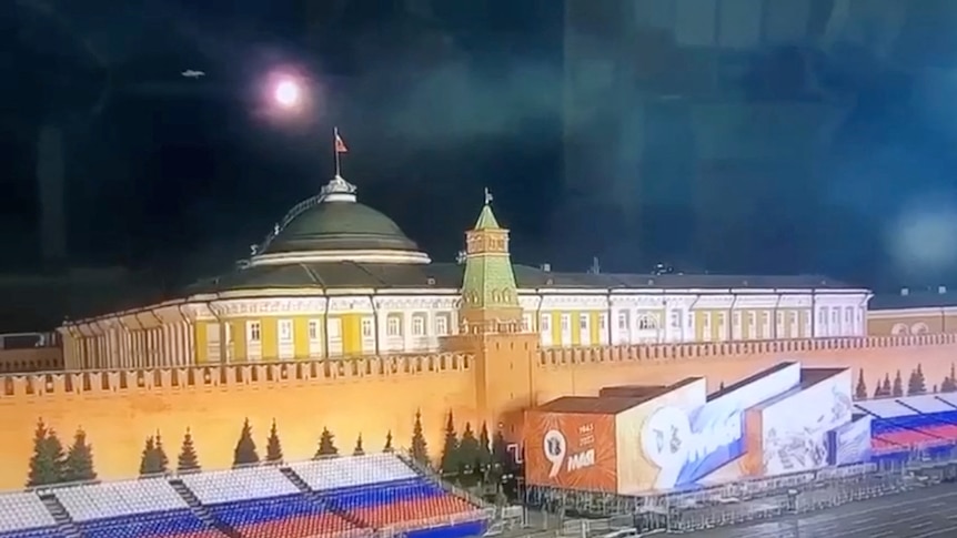 A light ball explodes in the dark sky above the Kremlin in Moscow. 