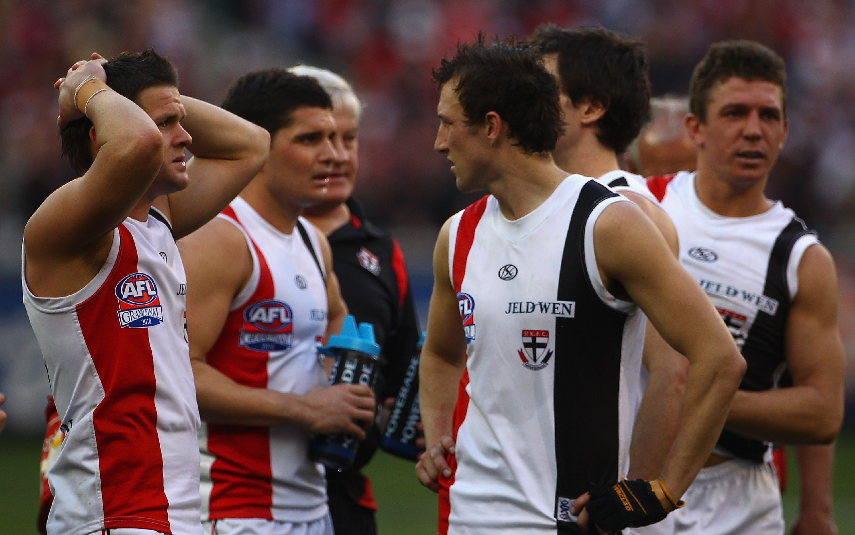 A group of tired and stunned St Kilda AFL players react after a grand final draw, including Steven Baker (right).