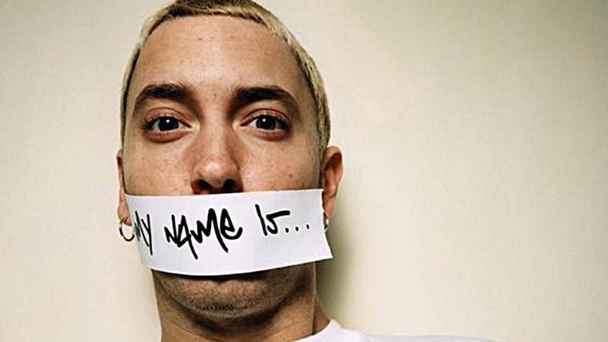 Close up of Eminem wearing white tee shirt, with 'My Name Is' taped across his mouth