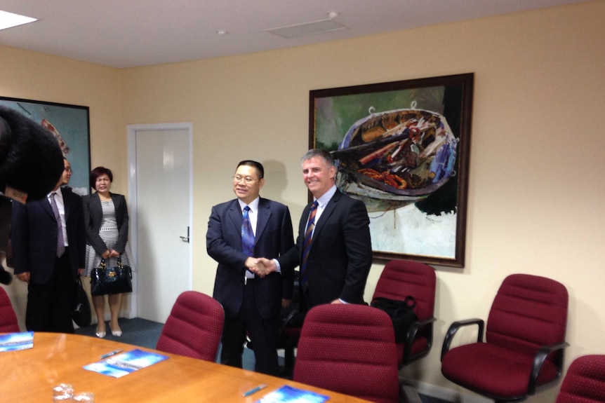 Mayor of Qinzhou Municipal People's Government, Tang Congyuan, and chair of Port of Townsville, Patrick Brady, shake hands.