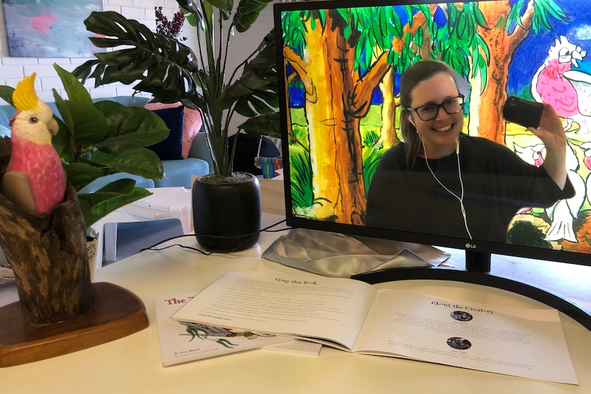 Kim appears on a computer screen with painted galahs behind her