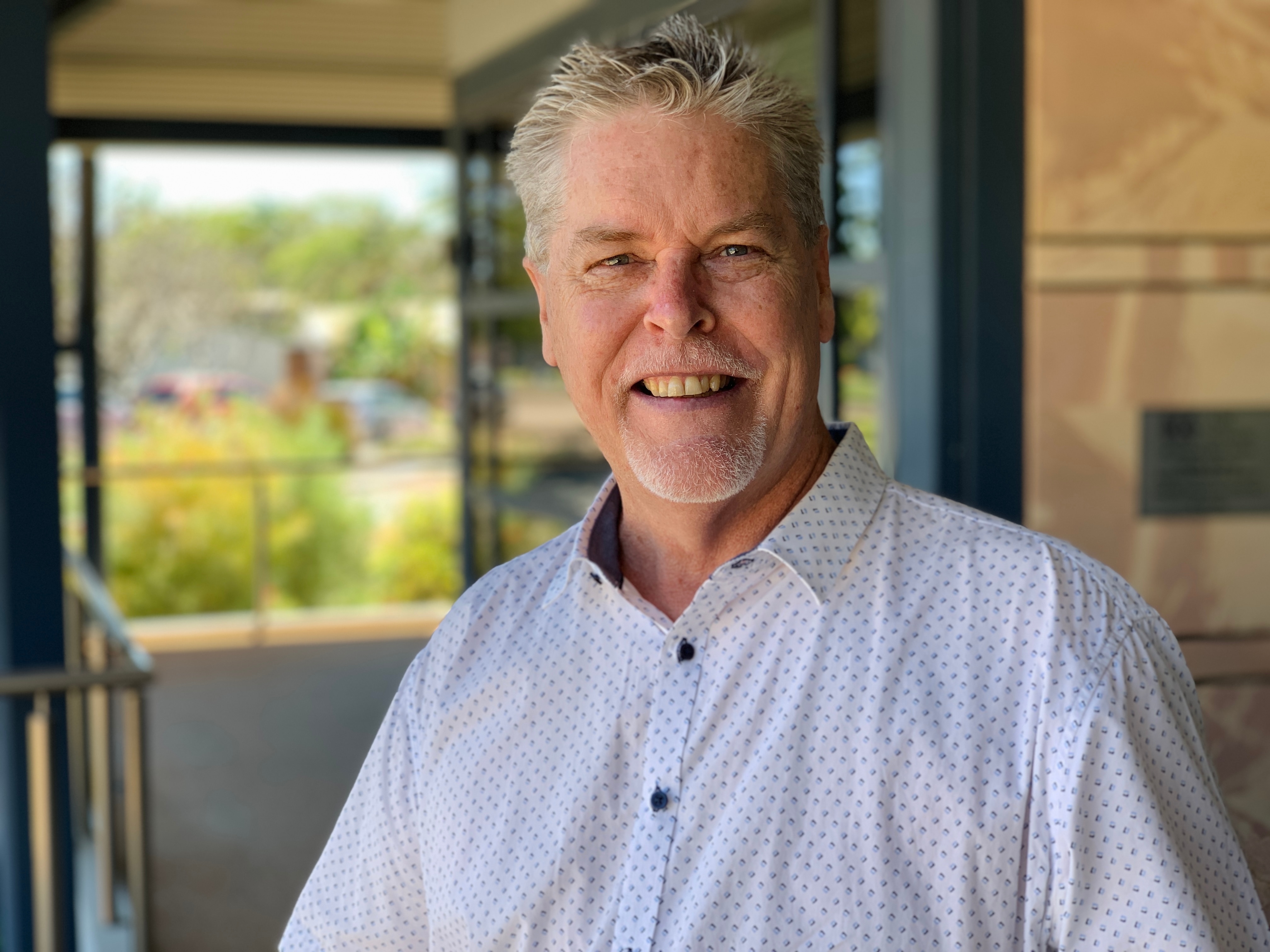 Pastor Peter Basell stands in from of a large window