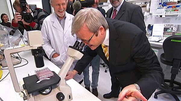 Prime Minister Kevin Rudd looks in a microscope at the opening of three new super laboratories