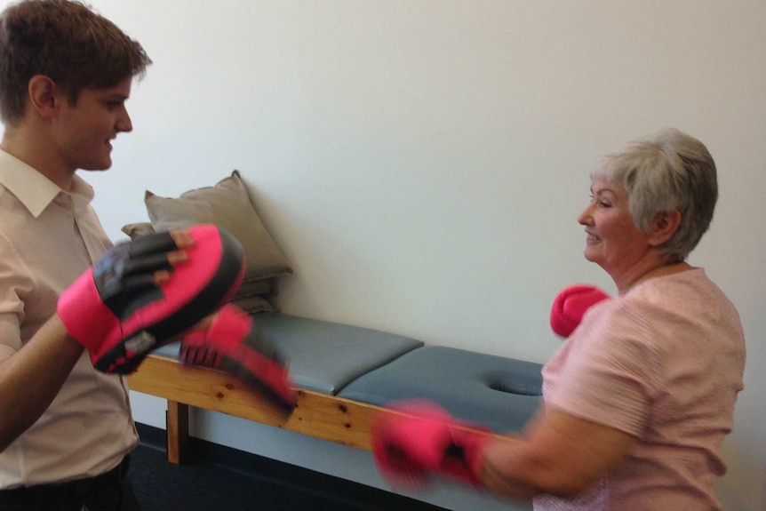 Stiff Person Syndrome-sufferer Rhonda Hodges works out on punching pads.