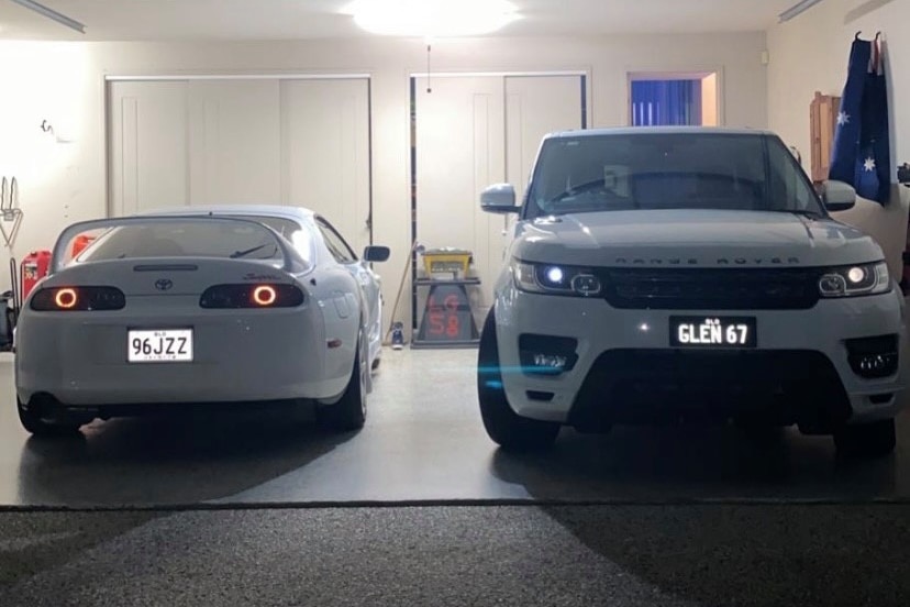 a white Range Rover and white Toyota Supra in a garage