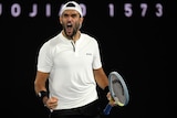 Dark-haired man in white shirt holds racquet, screaming