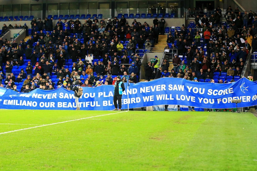 Fans hold a banner in tribute to Italian footballer Emiliano Sala at a Premier League game.