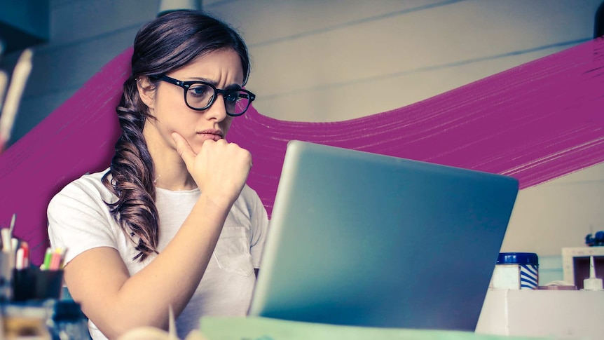 Photograph of a woman staring worriedly at her laptop screen.