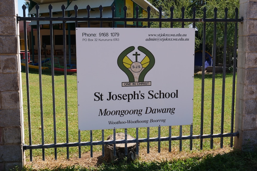 School sign attached to barred gate