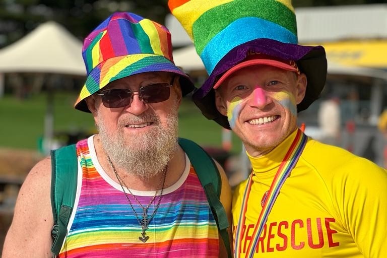 Two men in rainbow coloured hats