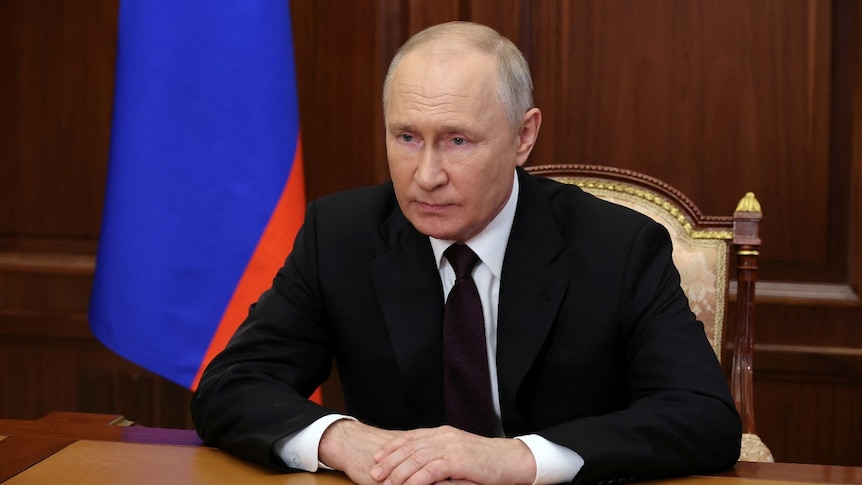 A man sitting at a desk with his hands clasped together