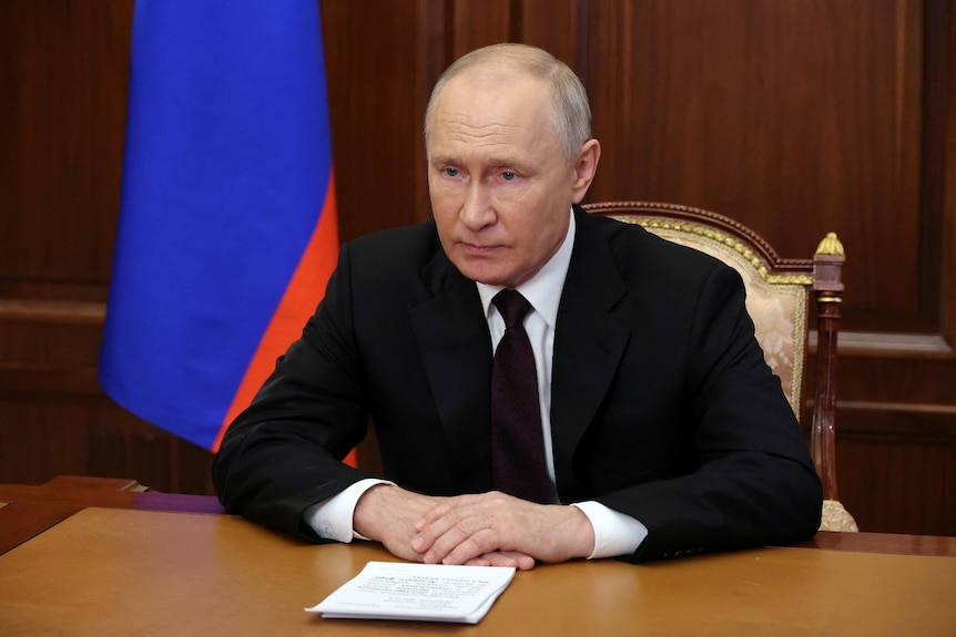 A man sitting at a desk with his hands clasped together