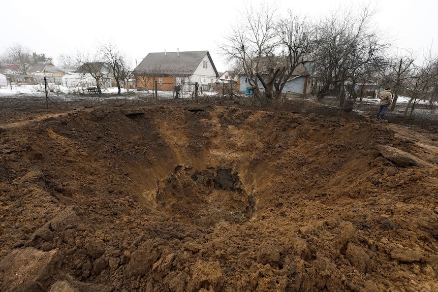 Large crater seen in ground after Russian missile strike.