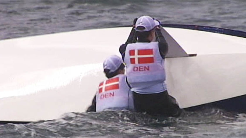 TV still of Prince Frederik (back to camera) trying to right his capsized sailing boat.