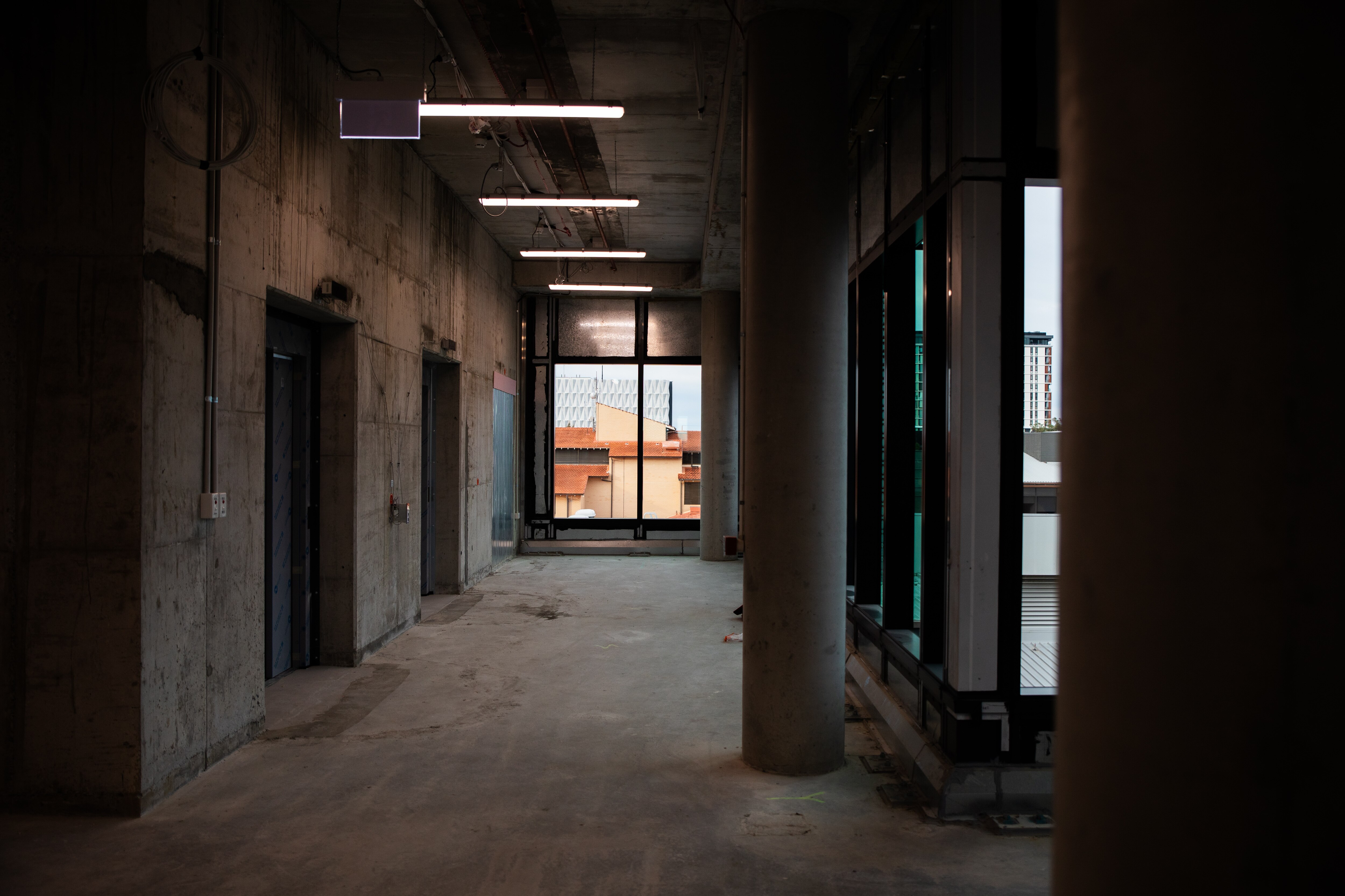 A construction site looking through to a window through which other buildings can be seen.