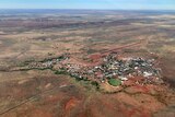 a small town surrounded by red dirt, and the green footy oval in foreground