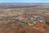 a small town surrounded by red dirt, and the green footy oval in foreground