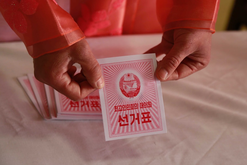 An electoral worker shows a ballot during North Korea's election.