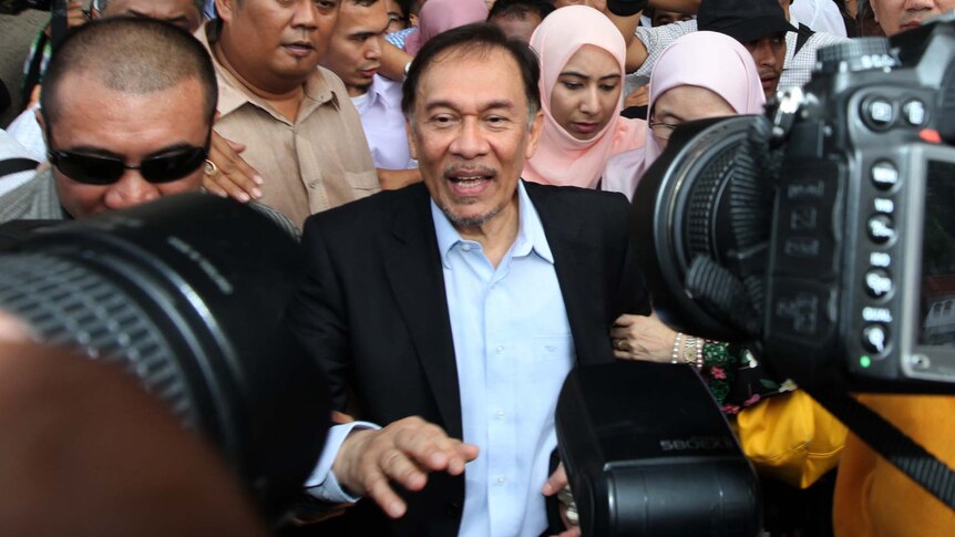 Anwar Ibrahim (C) walks out after his verdict at the High Court in Kuala Lumpur.