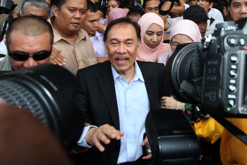 Anwar Ibrahim (C) walks out after his verdict at the High Court in Kuala Lumpur.
