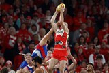 Chad Warner of the Sydney Swas takes a mark high above a pack of Western Bulldogs during an AFL game.