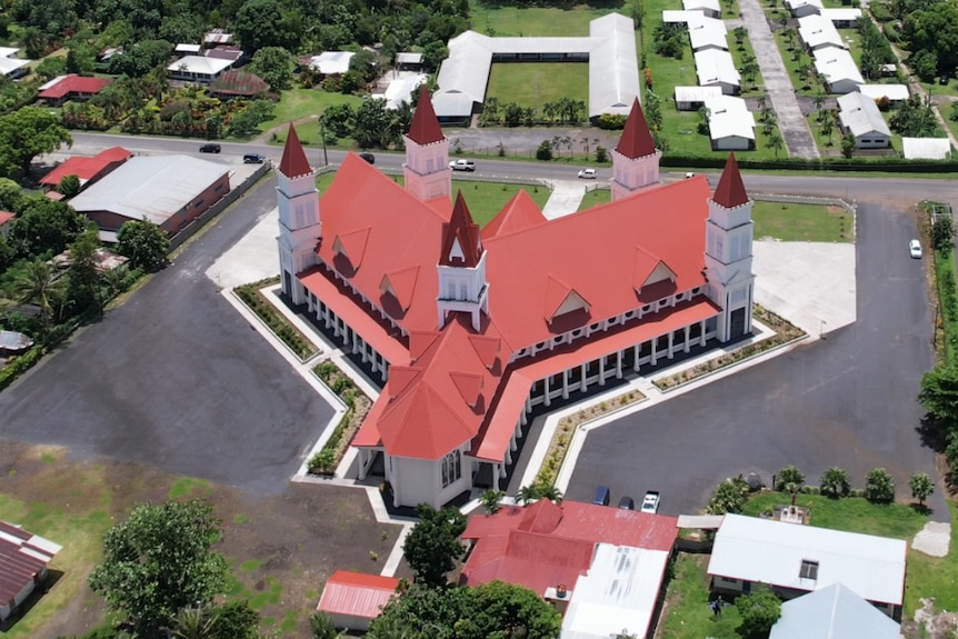 A bird's eye view of the maroon, Y-shaped roof of Lepea's church.