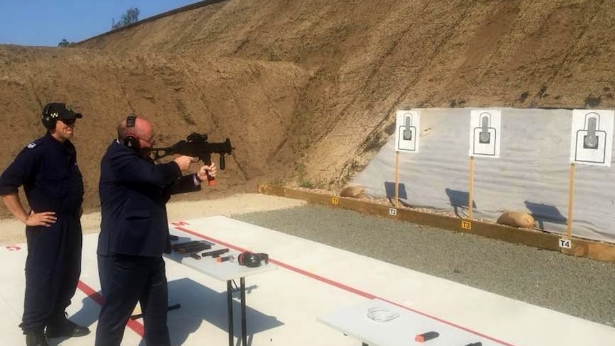 A man fires a gun at a target