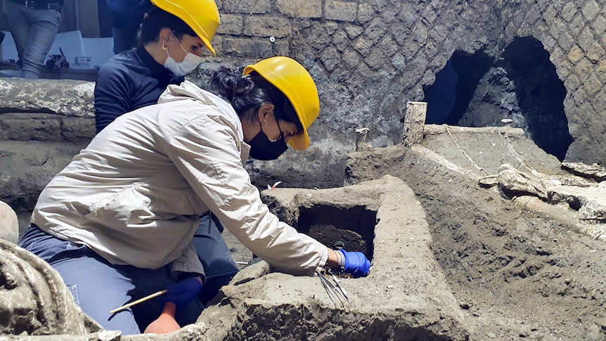 Two archaeologists work in a recently unearthed room in Pompeii. 