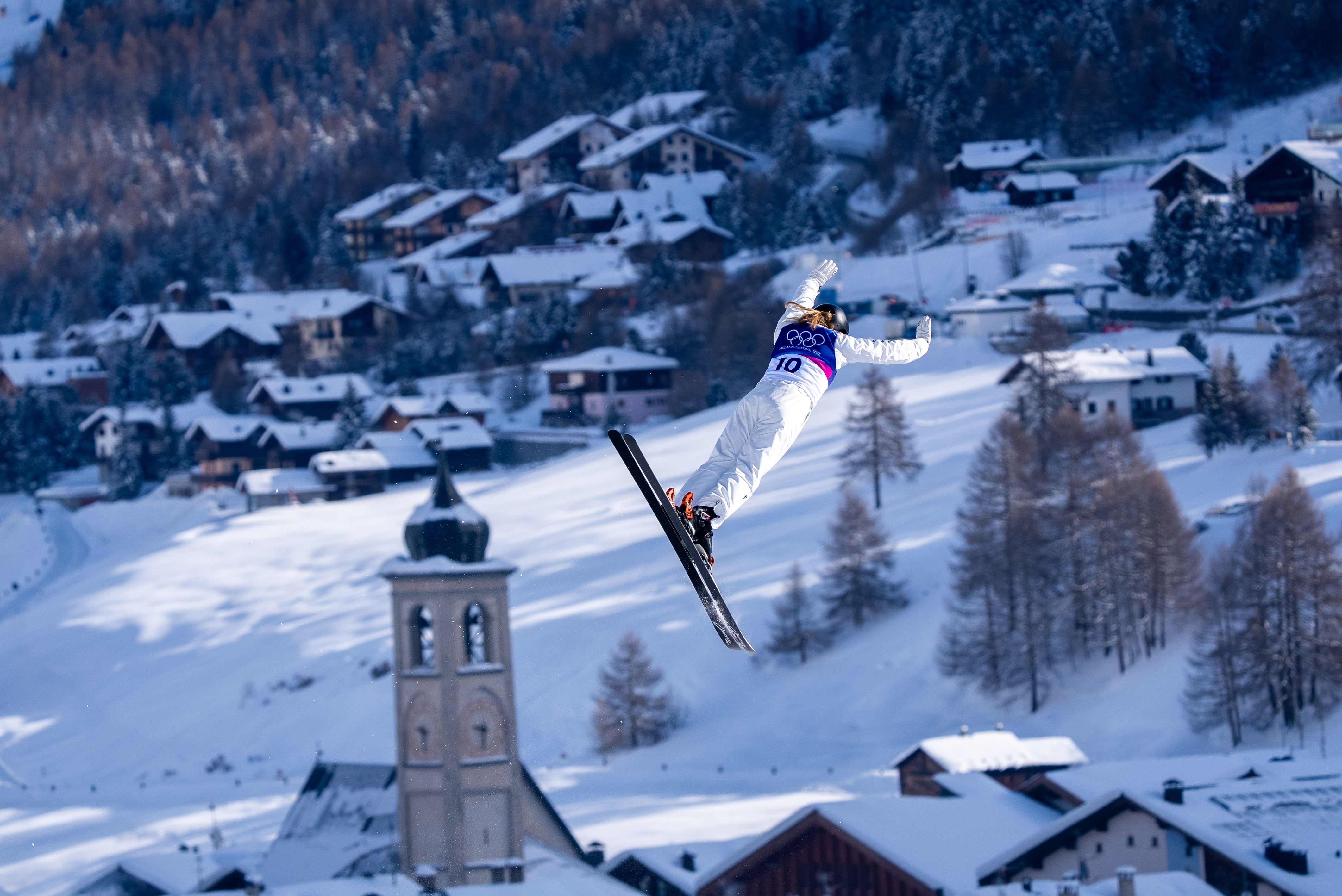 Abbey Willcox salta com uma igreja ao fundo