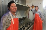 Michael and Alexandra Hicks in their mobile abattoir, showing the machine they had custom-built in Germany