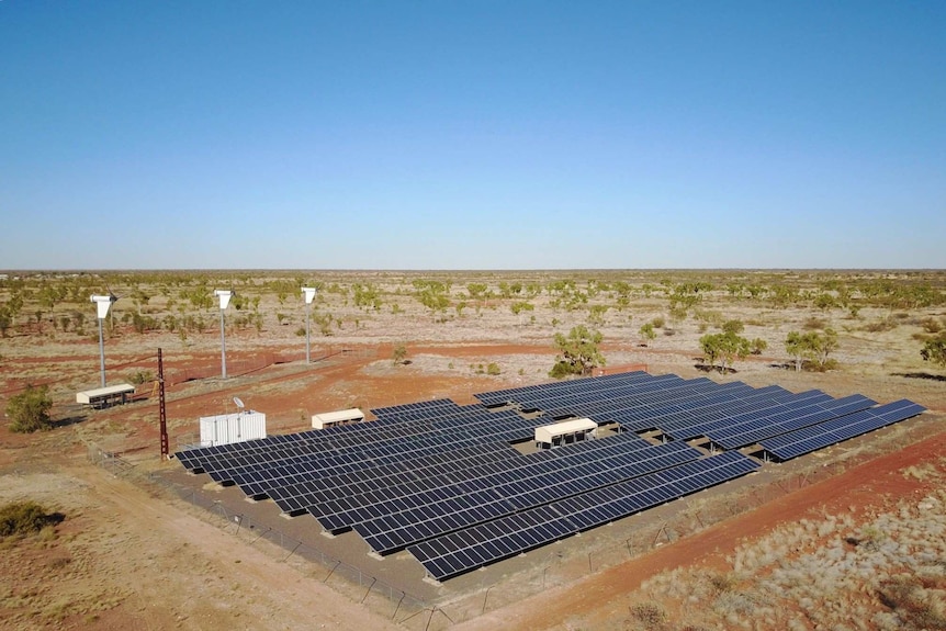 Alpurrurulam's solar farm and wind turbines sit on a red windswept plain